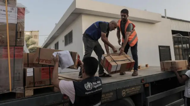 People unload supplies off a truck