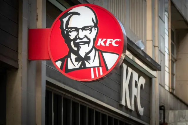 The sun shines on the logo of Colonel Sanders, founder of the Kentucky Fried Chicken fast food restaurant KFC, on October 18, 2023 in Bath, England.