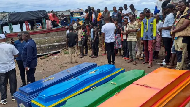 People stand by coffins after a boat capsized at the Congo river late on Friday in Mbandaka, Democratic Republic of Congo October 15, 2023.