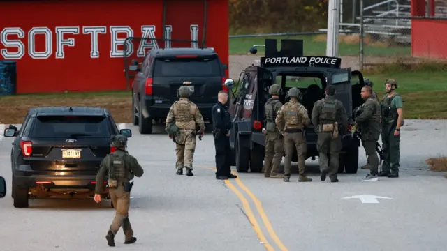 Officers stand next to armed tactical vehicles