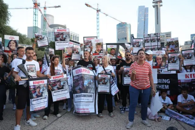 Relatives of Israeli hostages taken by Hamas hold signs with the names and photos of the missing and kidnapped people