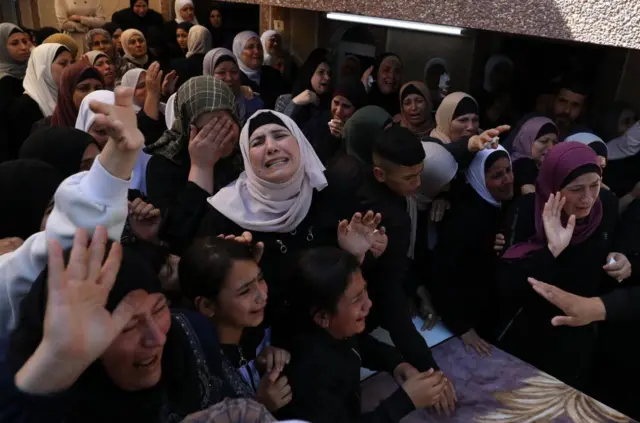 Relatives of a 17-year-old killed in clashes with Israeli settlers mourn at his funeral in Nablus