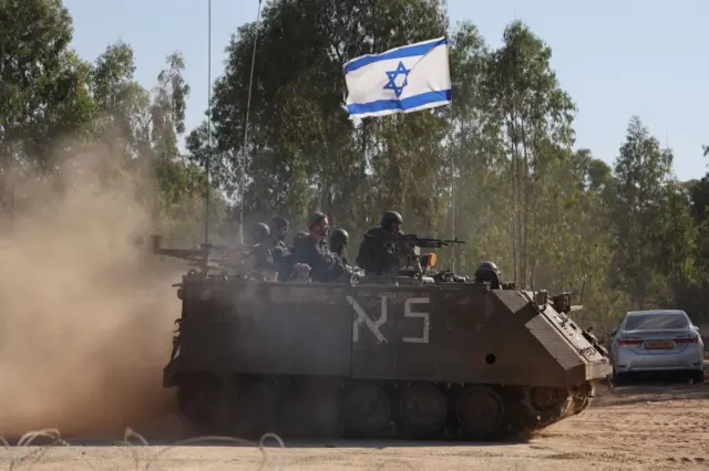 An Israeli tank with fighters on board with guns drawn