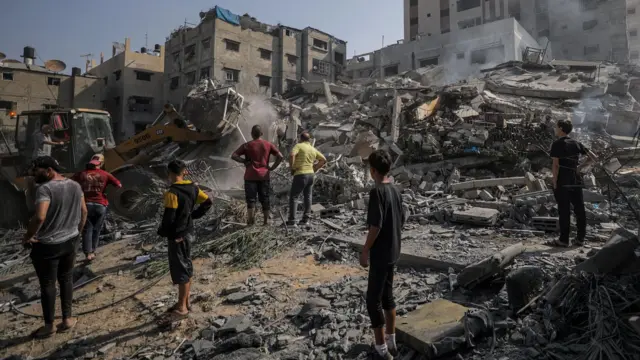 Palestinians survey rubble after an airstrike on the Gaza Strip