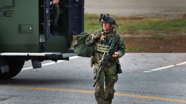 A heavily armed police officer patrolling a street outside of a high school in Lewiston