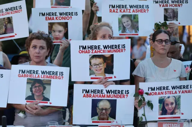 Relatives of Israeli hostages taken by Hamas hold signs with the names and photos of the missing and kidnapped people