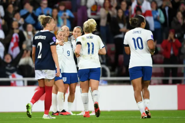 England players celebrate their goal v Scotland as a Scot watches on.