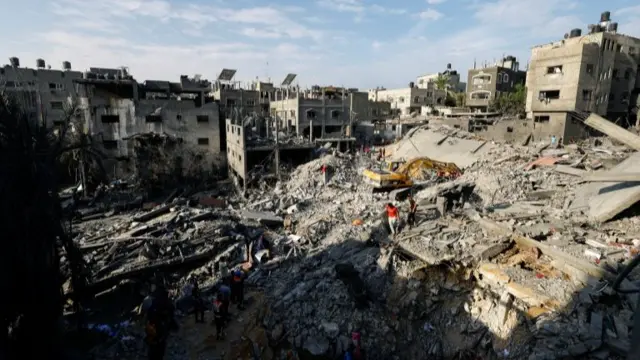 Emergency personnel work at the site of Israeli strikes on houses in Khan Younis in the southern Gaza Strip