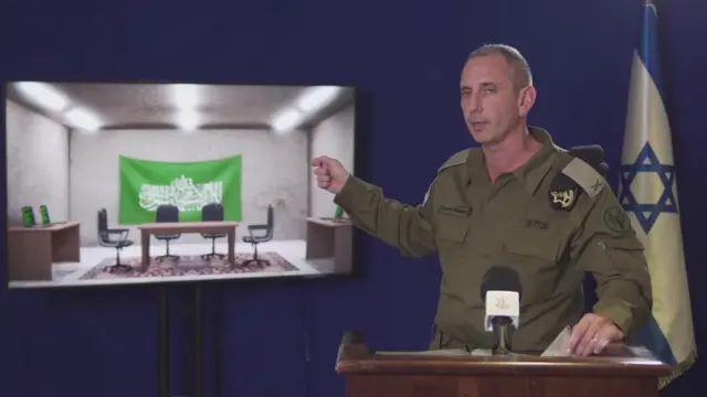 Daniel Hagari points to a screen showing an illustration of a Hamas command centre during a media briefing