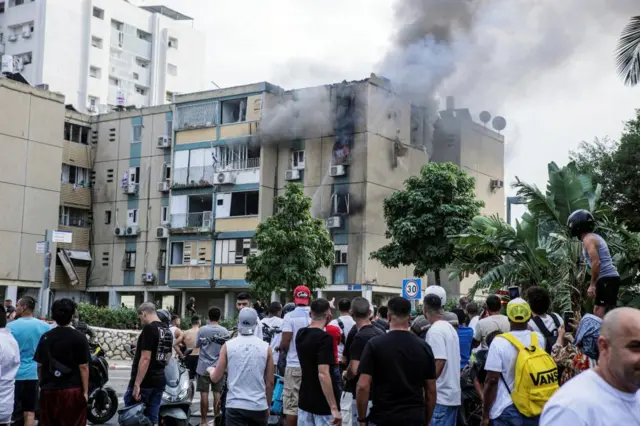 Smoke comes from a building hit by a rocket in Tel Aviv