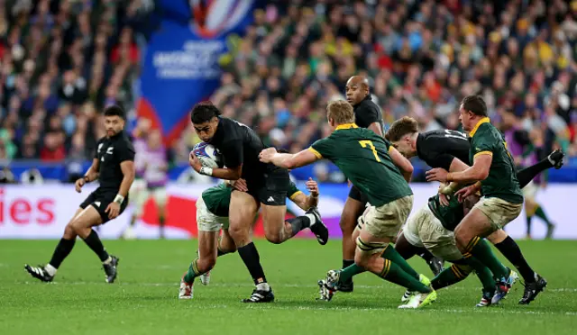 New Zealand player breaks through a tackle