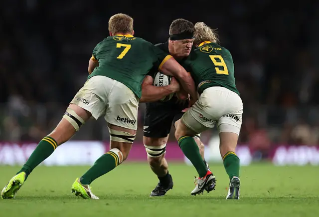 Scott Barrett of New Zealand is tackled by Pieter-Steph du Toit and Faf de Klerk