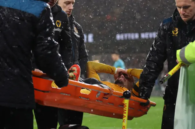 Neto is carried off on a stretcher after pulling his hamstring.