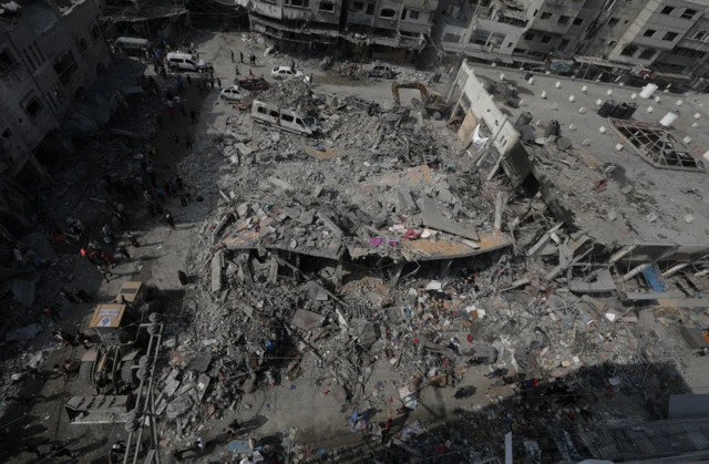 Palestinians search for bodies and survivors among the rubble after Israeli airstrike destroyed a building - 28 October 2023