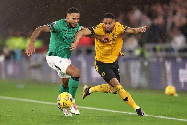 Cunha tries to run the ball past Lascelles near the touchline.