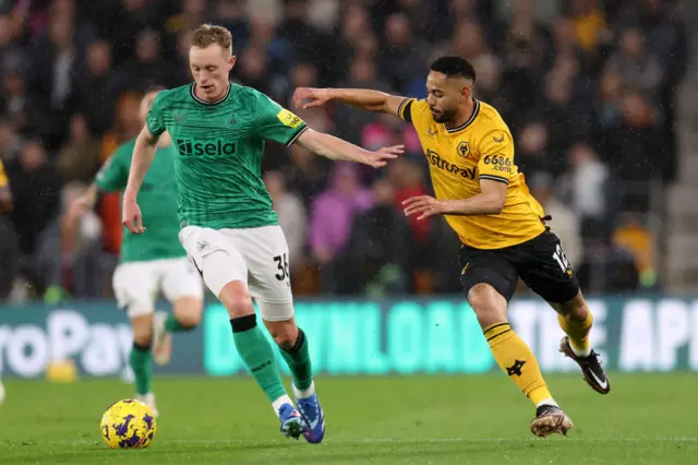 Cunha presses Longstaff who attempts to dribble the ball away.