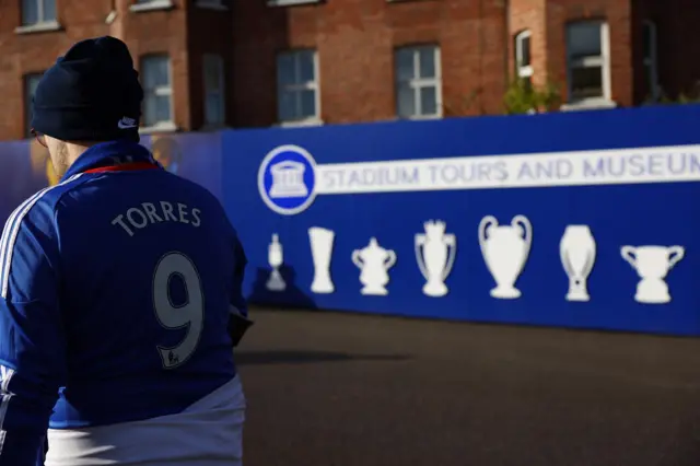 A fan walks past the champions wall at Stamford Bridge.