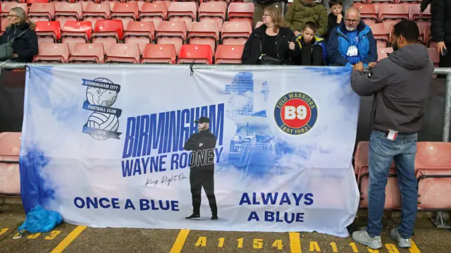 Birmingham fans hold a Wayne Rooney flag