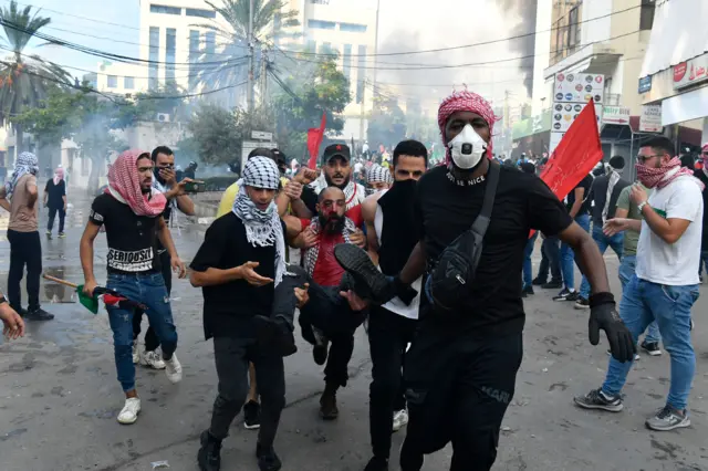 Protesters carry an injured man during clashes with security forces outside the US embassy at a protest following a strike on a hospital in the Gaza Strip, in Beirut, Lebanon, 18 October 2023