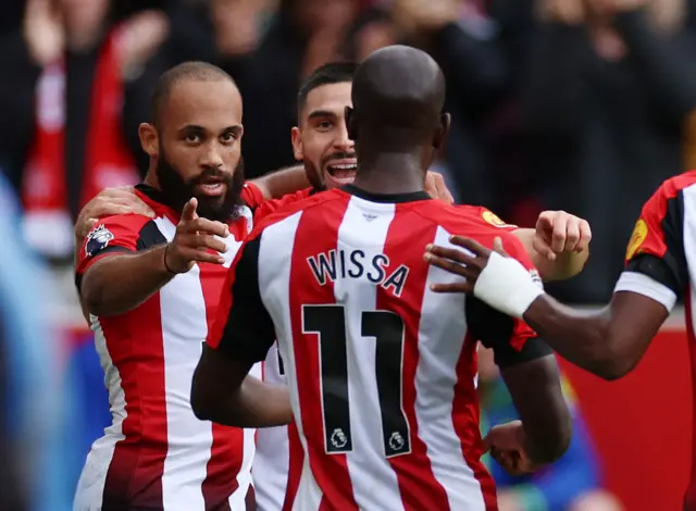 Mbeumo, Wissa and Maupay celebrate together after Brentford's goal.