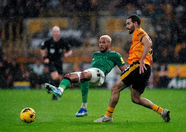 Joelinton slips as he passes the ball off under pressure from Ait-Nouri.