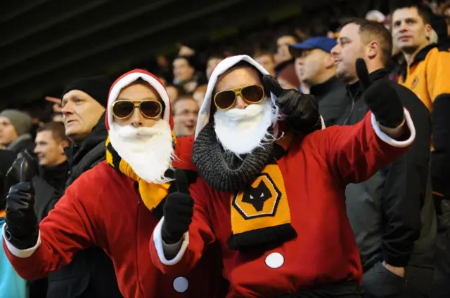 Wolves fans sit in the stands with Santa hats and beards on Boxing day.