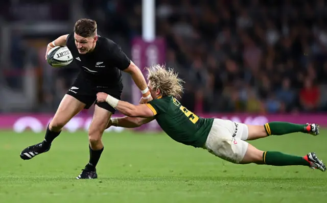 Beauden Barrett breaks a tackle from Faf De Klerk