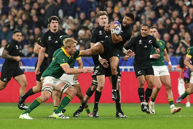 Richie Mo'unga jumps in the air to catch a high ball