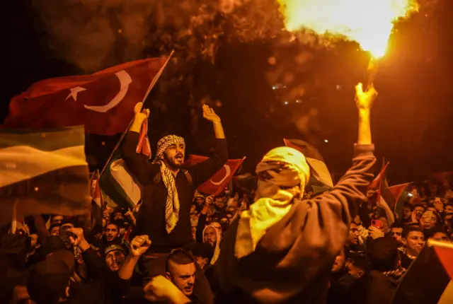 Protesters shout slogans and light flares during a protest in solidarity with the Palestinian people outside the US Consulate in Istanbul, Turkey