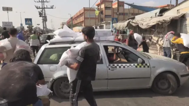 A car is loaded with supplies from the UNRWA's warehouse