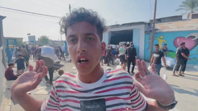 Displaced Palestinian Abdulrahman al-Kilani gestures at the UNRWA warehouse