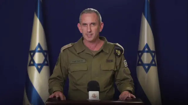 IDF spokesperson Daniel Hagari at a press conference. He is in military uniform. Two Israeli flags are behind him.