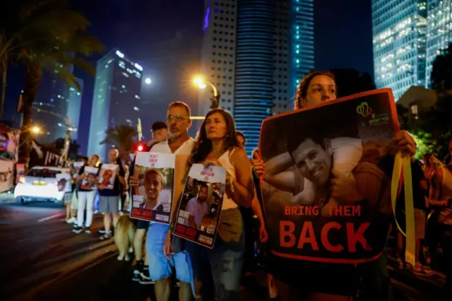 People hold posters calling for the hostages to be released