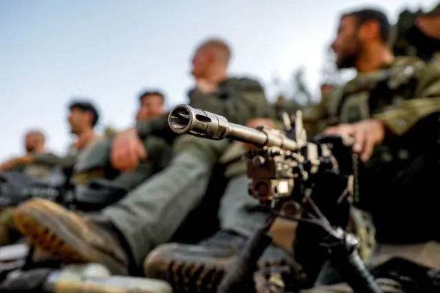 An Israeli army soldier sits by a machine gun