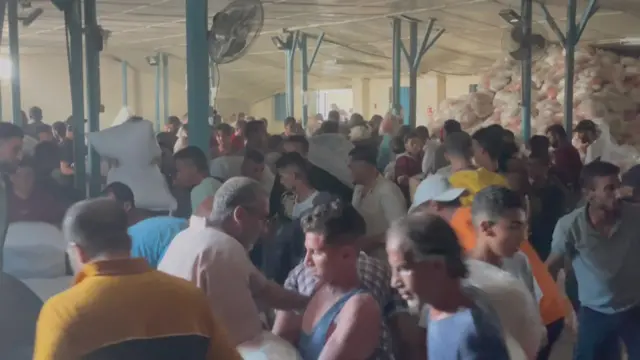 A crowd of people in UNRWA's warehouse in Deir al-Balah