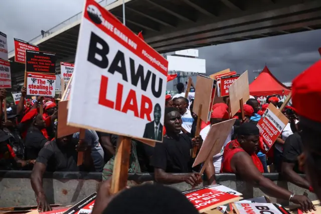 Ghanaians collect placards from a pick-up truck as they gather to protest against the deteriorating economic conditions in the country and against the Bank of Ghana, a demonstration organised by the opposition party, National Democratic Congress (NDC), in Accra on October 3, 2023.