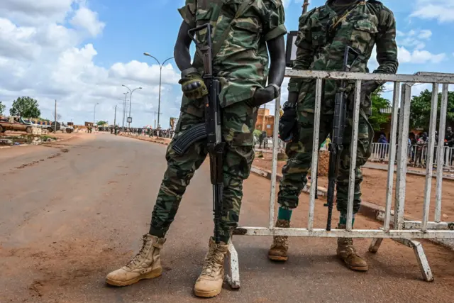 Nigerien police soldiers stand guard ouside the Niger and French airbases in Niamey as supporters of Niger's National Council for the Safeguard of the Homeland (CNSP) gather on August 27, 2023.