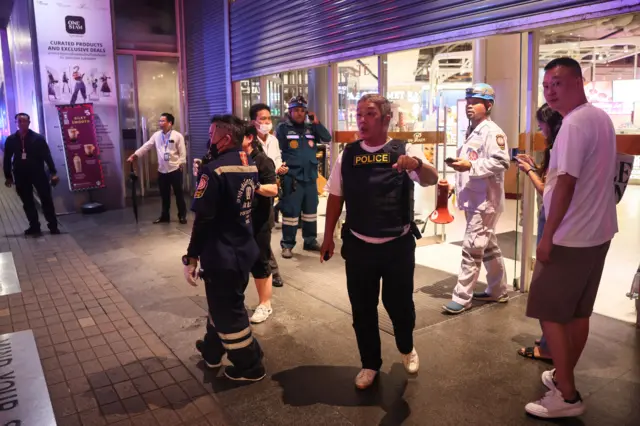 Emergency workers stand outside a shuttered shopping centre