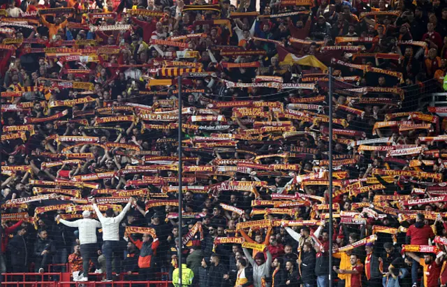 Galatasaray fans raise their scarves during the game at Old Trafford