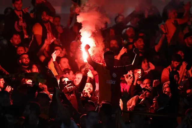 A Galatasaray fan lights a flare during the game