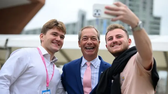 Farage takes a selfie with two men either side at Tory Party conference