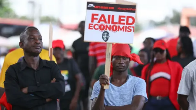 A demonstrator holds a placard carrying the portrait of Ghana President Nana Akufo-Addo, during a protest organised by the opposition party, National Democratic Congress (NDC) against the deteriorating economic conditions in the country and against the Bank of Ghana, in Accra - 3 October 2023