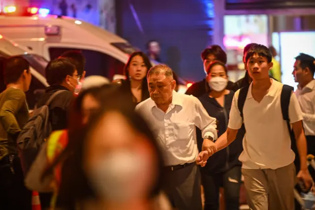 A group of people exit the Siam Paragon shopping centre