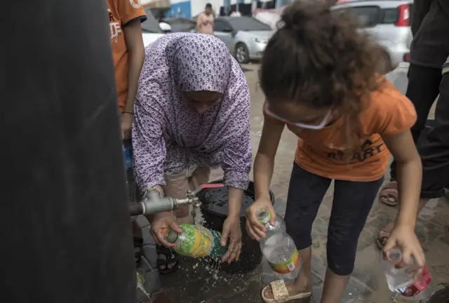 Children fill bottles with water inside a tent complex in a tent camp provided by the United Nations Development Programme (UNDP) for displaced Palestinians who lost their homes in the Israeli bombardment, in Khan Yunis, 29 October 2023.