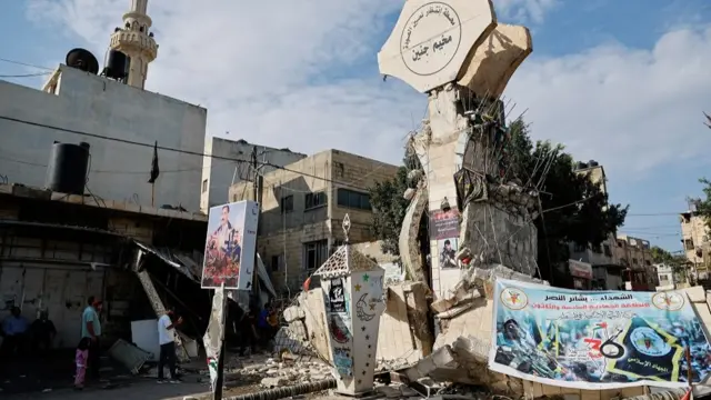 Palestinians stand in front of a destroyed entrance into the Jenin refugee camp, following an Israeli raid in Jenin, in the Israeli-occupied West Bank October 30, 2023.