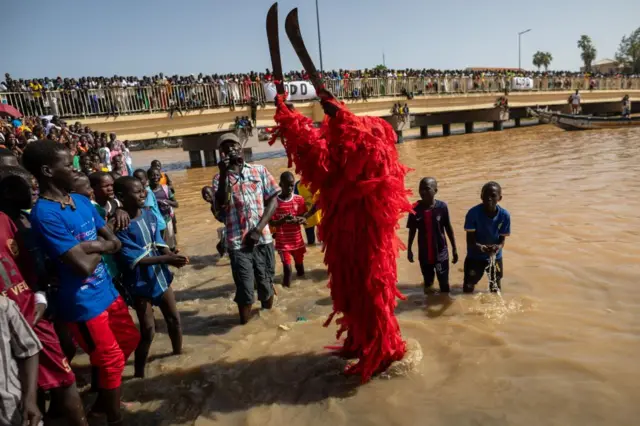 A man known as a 'Kangkourang' (L), performs a ritual before dugout races in Saint Louis, Senegal, 28 October 2023. The traditional races showcase hundreds of local fishermen who compete in a 6 kilometre race aboard long and narrow dugouts on the Senegal river. The teams comprise 50 to 70 rowers representing geographical areas from their neighbourhoods. Dugout races in Saint Louis, Senegal - 28 Oct 2023