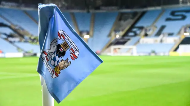 Coventry City corner flag with stadium seats in background