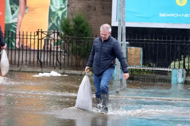 Man carrying sandbag through Newry flood