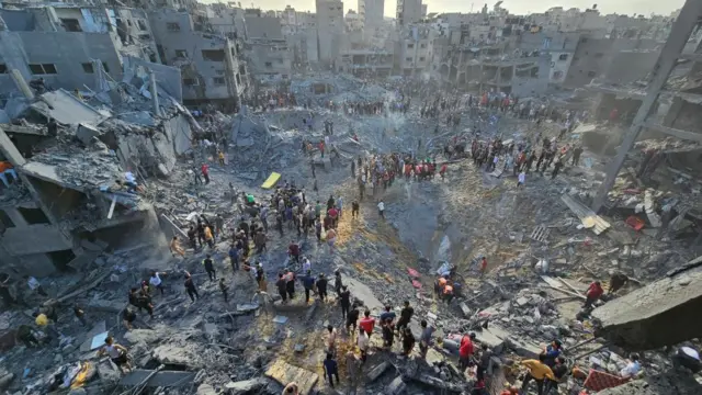 An aeiral view of the Jabalia camp blast, several impact craters and dozen of people are visible amongst the rubble