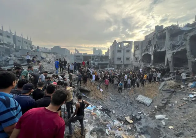 Palestinians search for casualties at the site of Israeli strikes on houses in Jabalia refugee camp in the northern Gaza Strip